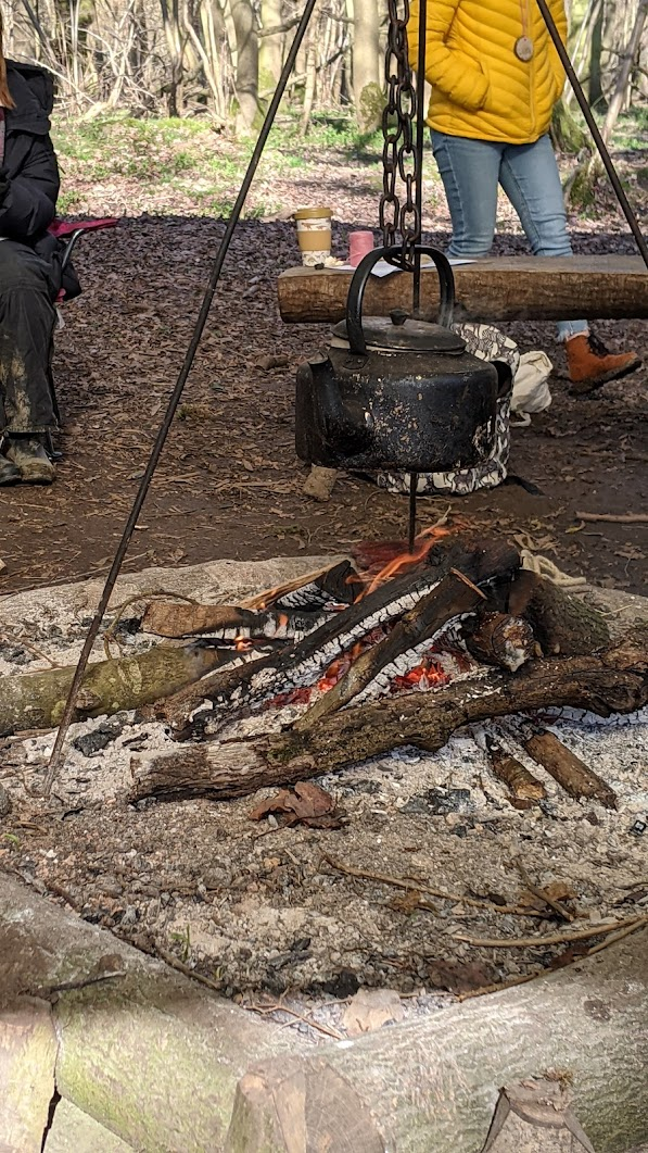 A blackened kettle and dinner cooking over the campfire